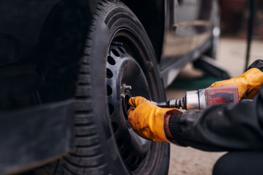 Mechanic installing winter tire on car